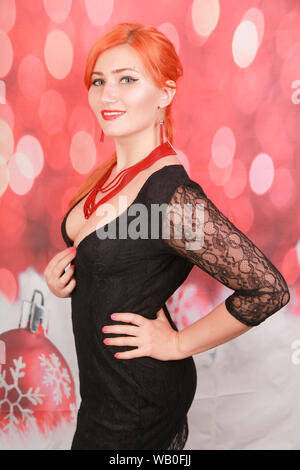 pretty stylish girl in red coral jewelry posing on red background Stock Photo