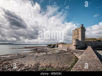 Sun shining on the ruins of Carrigaholt Castle which overlooks the Shannon Estuary in County Clare in Ireland Stock Photo