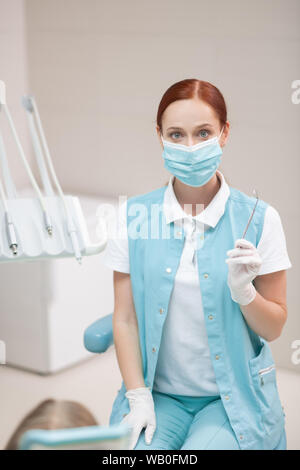 Child dentist sitting near dental chair with girl Stock Photo