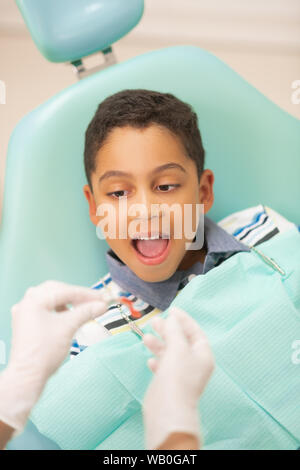Boy opening mouth while dentist putting mouth guard Stock Photo