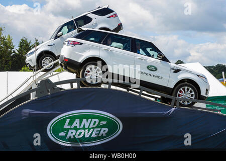 Land Rovers (Range Rover & Discovery) driving on high thrilling steep descent - Land Rover Experience display course Great Yorkshire Show, England, UK Stock Photo