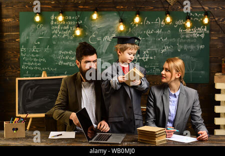 Home tutor helping boy with studies using modern laptop. Teacher sets high expectations for his students. learning and people concept. Lesson with qua Stock Photo