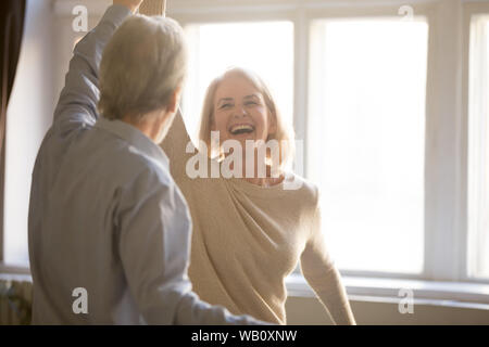 Happy middle aged mature woman enjoying dancing with elder husband Stock Photo