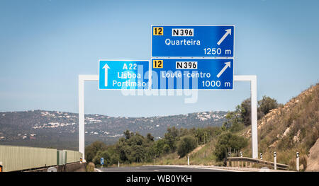 Faro, Portugal - September 16, 2018: blue road sign on A22 highway indicating the direction of Lisbon, Portugal on a summer day Stock Photo