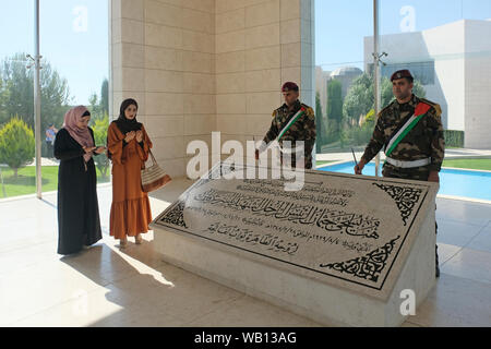 Palestinian visitors praying at Yasser Arafat's tombstone in mausoleum at the PNA Palestinian National Authority presidential headquarters in Ramallah a Palestinian city in the central West Bank in the Palestinian territories Stock Photo