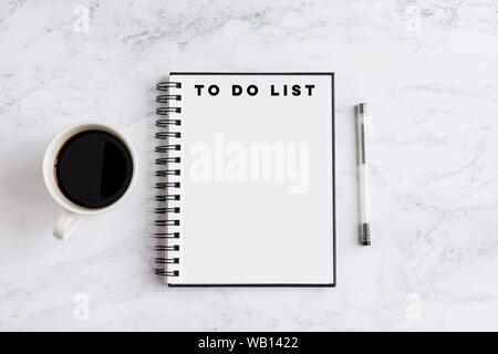 To do list writing on notebook. Notebook on desk with coffee cup and a pen. Stock Photo