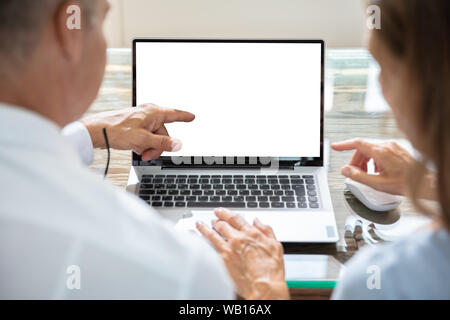 Close-up Of Two Businesspeople Working On Laptop Stock Photo