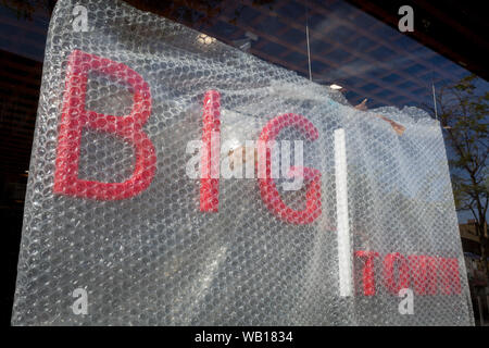A detail red lettering, the frontage of a new restaurant business to be called 'Big Town' and offering West African food, is still covered in Bubble-Wrap during the property's conversion on the Walworth Road in south London, on 23rd August 2019, in London, England.