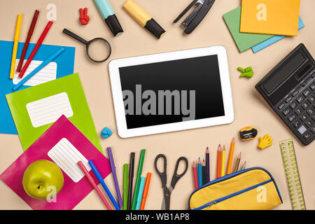 Flat lay photo of workspace desk with school accessories or office supplies on pink background. Stock Photo