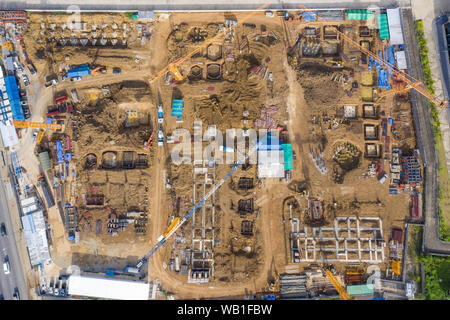 Aerial drone view of excavator loading the tipper truck at the construction site Stock Photo