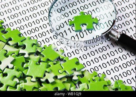 puzzles and magnifying glass on a binary code Stock Photo