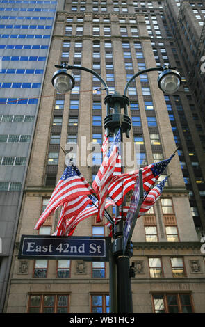 US flags attached to street lamps outside office blocks on 42nd street, Manhattan, NYC.
