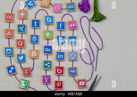 QUEENSTOWN, SOUTH AFRICA - 7 JULY 2019 -Social media background with social media logos on wooden game blocks joined with embroidery thread and needle Stock Photo