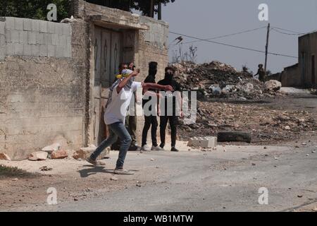 Nablus, Palestine. 23rd Aug, 2019. A Palestinian protester uses a slingshot to hurl stones at Israeli soldiers during clashes, after a protest against the expanding of Jewish settlements in Kufr Qadoom village near the West Bank city of Nablus, Aug. 23, 2019. Credit: Xinhua/Alamy Live News Stock Photo