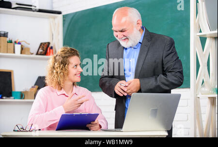 Attention. pass exam. teachers room. senior teacher and woman at school lesson. student and tutor with laptop. brainstorming on new project working. happy student girl with tutor man at blackboard. Stock Photo