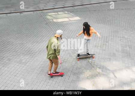 high angle view of two friends riding on skateboards at street Stock Photo