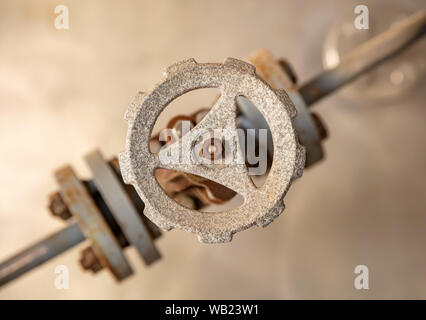 Industrial pipeline and valve close up, blur background. Old rusty control equipment, abandoned plant industry Stock Photo