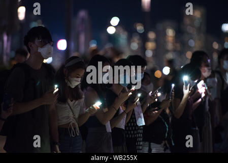 Protesters shine their phone lights as a sign of unity and peace during the demonstration.Protesters held hands to create long human chains in peaceful protest against the extradition bill. Some protesters carried various placards asking and thanking other countries for their support while others also shined their phone lights as a sign of unity and peace. Stock Photo