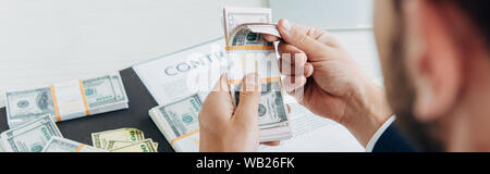 cropped view of businessman using calculator near money and contract Stock Photo