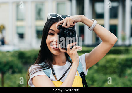 attractive and asian woman with glasses sticking out tongue and taking photo Stock Photo