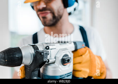 selective focus of handyman using hammer drill Stock Photo