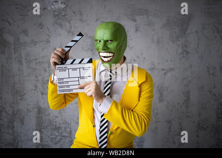 Jim mask yellow suit, green mask, as in the shooting a movie in the hands of an artificial hare looks at him and wants to eat Stock Photo - Alamy