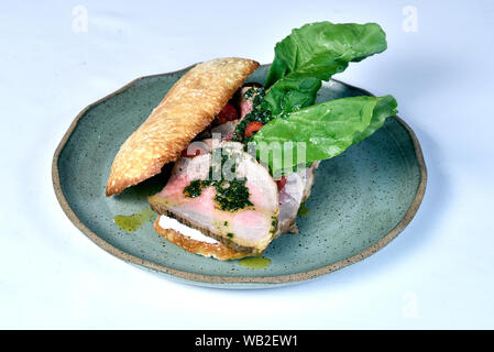 beef sandwich with rucula, cherry tomatoes and pesto. Stock Photo
