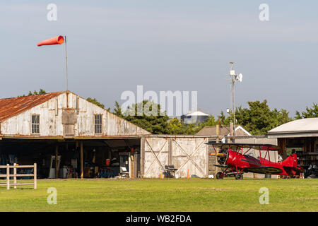 A red Biplane on the field in Martha's Vineyard Stock Photo