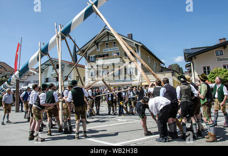 One of the oldest traditions still maintained in Upper Bavaria is the setting up of the traditional maypole along with music and drinking beer. Stock Photo