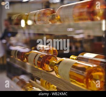 Resting wine bottles stacked on wooden racks in a shopping mall Stock Photo