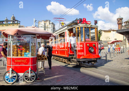 Istanbul, Turkey - August 05, 2019: The nostalgic tram beside a cart selling traditional Turkish simit at the Taksim end of the famous Istiklal Caddes Stock Photo