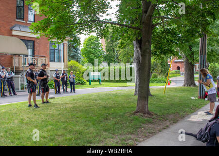 OTTAWA, ONTARIO, CANADA - August 23, 2019: An activist and police officers share a moment of mutual gratitude for peace as a protest concludes. Stock Photo