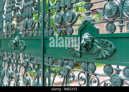 Patterned ancient closed green gate with images of lions Stock Photo