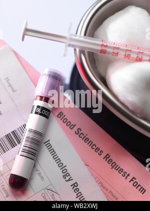 Human blood sample alongside blood test request form. Stock Photo