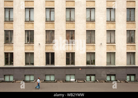 Man walkng past a building in Minsk, Belarus. Stock Photo