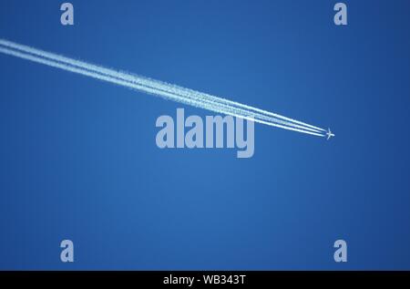 Low angle shot of an airplane flying in a clear blue sky in Austria. Stock Photo