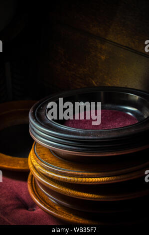 Wooden collection plates are stacked on a pew in a church Stock Photo
