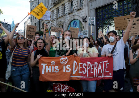 London, UK. 23rd Aug, 2019. Environmental activists are seen shouting slogans outside the Brazilian embassy in London. Extinction Rebellion environmental activists gathered outside the Brazilian embassy in London to raise awareness of fires that are devastating the Amazon. They demand international pressure from the G7 to force Bolsonaro government to control the fires and guarantee the amazon rainforest protection and indigenous lives. Credit: SOPA Images Limited/Alamy Live News Stock Photo