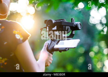 A girl holding a camera mounted on a gimbal. Stock Photo