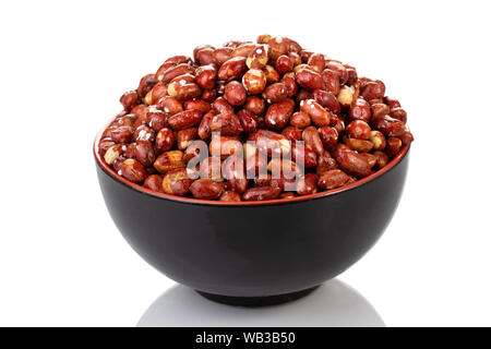 A black bowl filled with roasted peanuts on a white background. Stock Photo