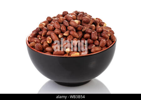 A black bowl filled with raw peanuts on a white background. Stock Photo