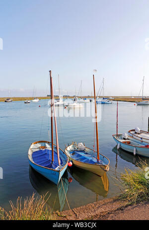 Two sailing dinghies tied-up by the quay in the east of the port of Wells-next-the-Sea, Norfolk, England, United Kingdom, Europe. Stock Photo