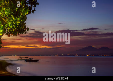 Indonesia. Tropical bay with boats on calm water. Colored sky after sunset Stock Photo