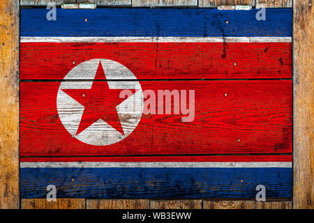 National flag of North Korea on a wooden wall background.The concept of national pride and symbol of the country.Flag painted on a wooden fence with m Stock Photo