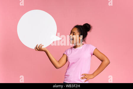 African American girl making announcement at white blank speech bubble Stock Photo