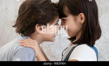 Funny little cute kids siblings happy faces bonding, side view Stock Photo