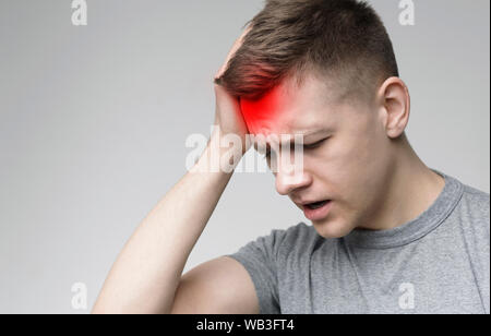Frustrated handsome young man touching his head Stock Photo