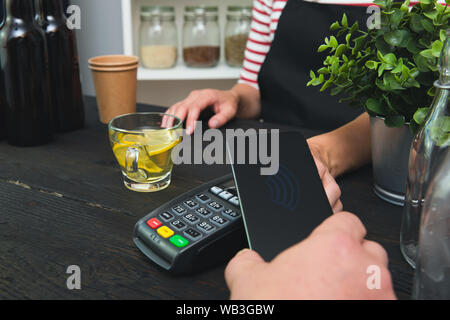 Customer making wireless or contactless payment using smartphone Stock Photo