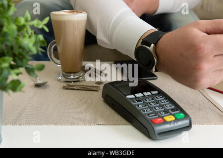 Customer making wireless or contactless payment using smartwatch, nfc payment Stock Photo