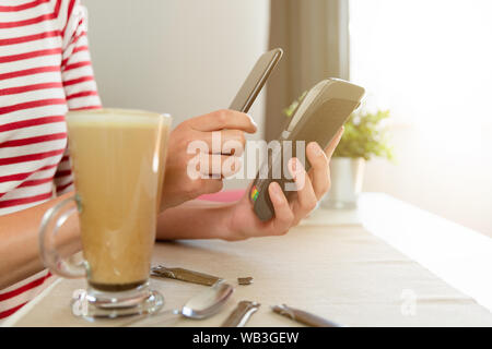 Customer making wireless or contactless payment using smartphone, nfc payment Stock Photo